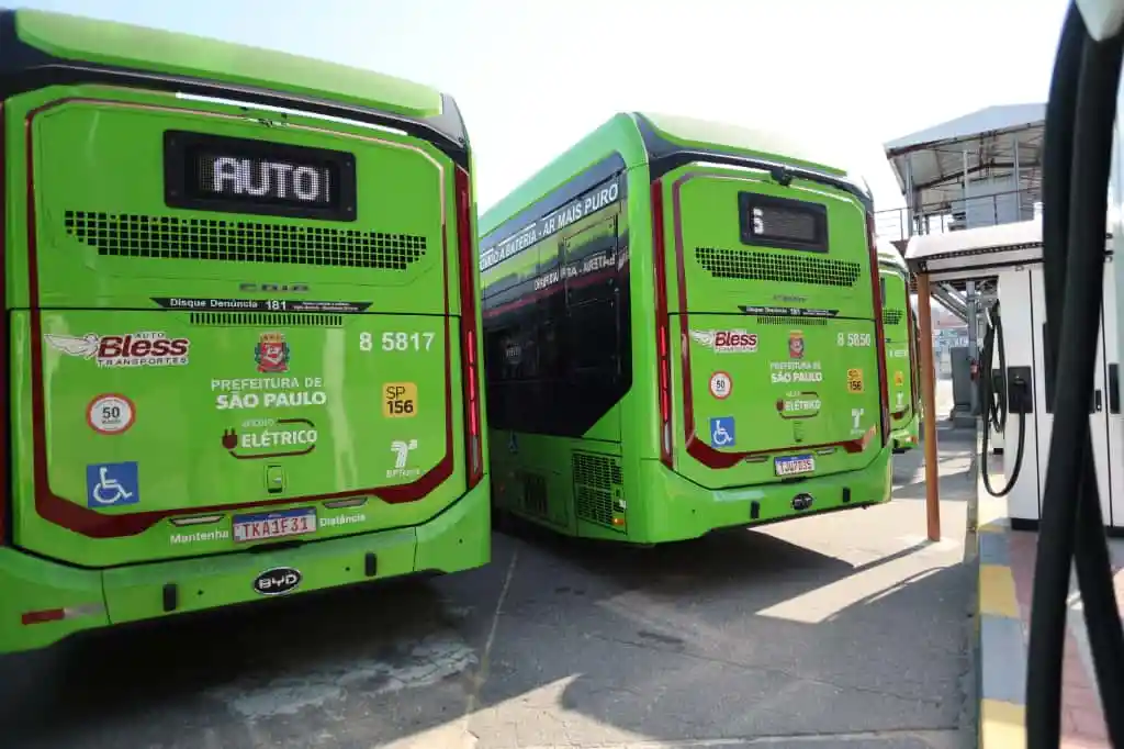 Dois ônibus elétricos carregando na garagem da Auto Bless